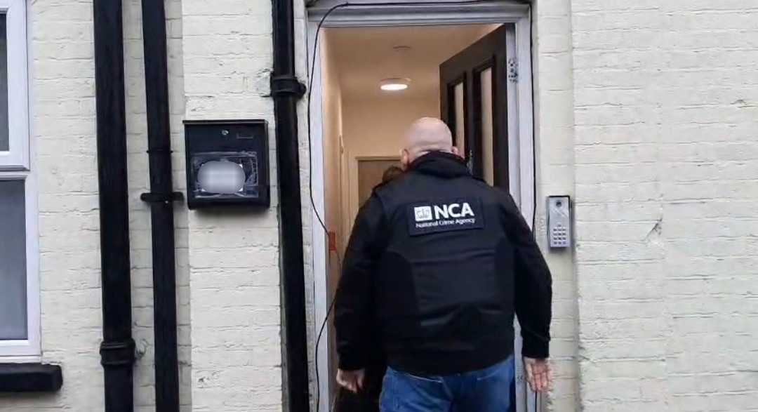 NCA officer entering a building