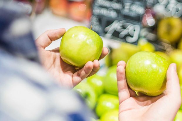 A person holding an apple in each hand
