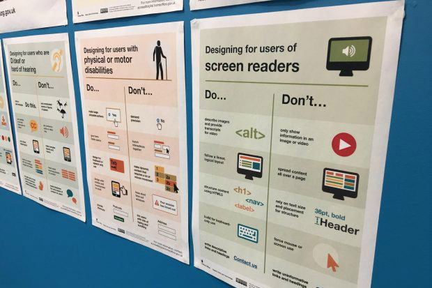 Photo of a set of posters about designing for accessibility displayed on a wall