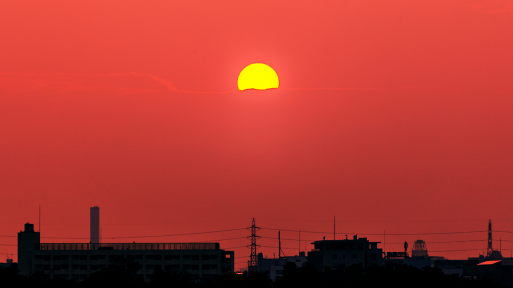 A sun in the sky over a city skyline.