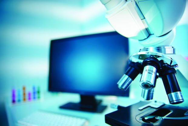 Image of a computer with a microscope at the forefront