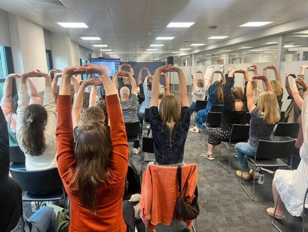 colleagues at the wellbeing session taking part in guided meditation, stretch,