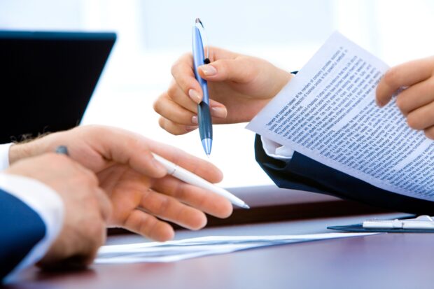 Man and woman reading notes in office