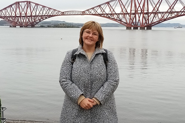 A lady standing in front of a bridge
