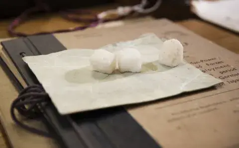 Three sugar cubes on white paper belonging to Wing Commander John Heagerty, discovered in the Map Room in the 1980s. 