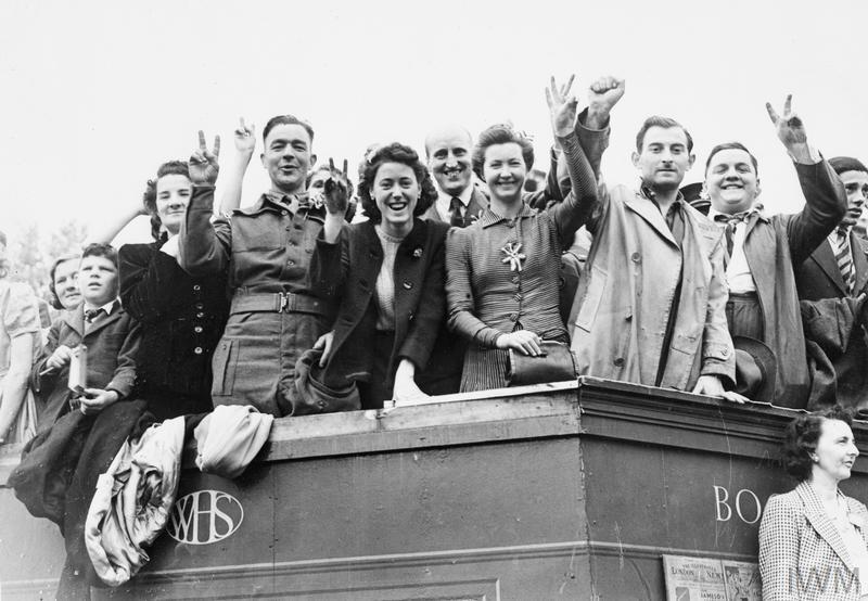 Revellers give the V-Victory sign as they celebrate VE Day outside the Houses of Parliament.