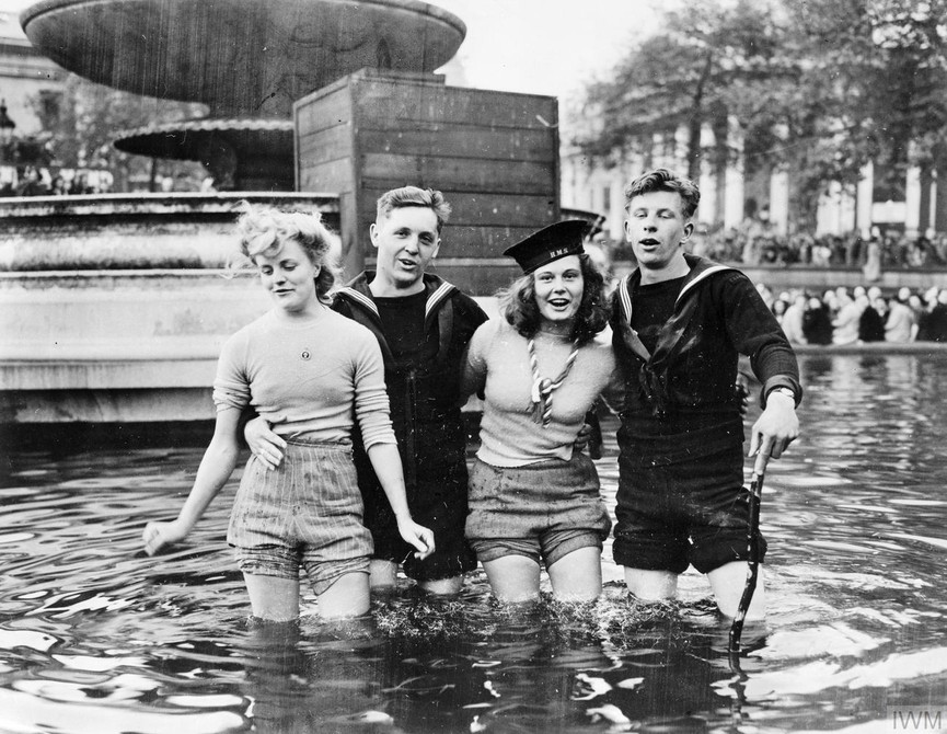 Joyce Digney, Cynthia Covello and two British sailors wading in the fountains in Trafalgar Square on VE Day.