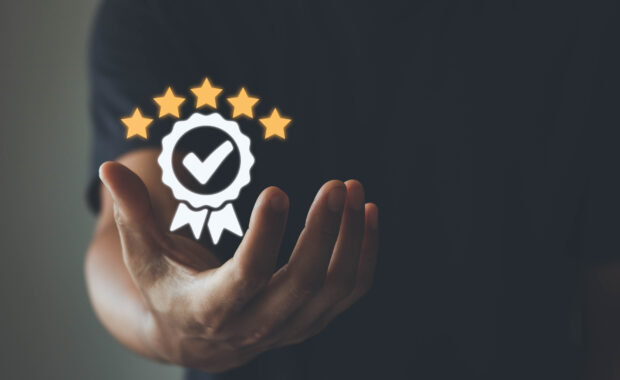 The hand of businessmen shows the sign of the top service Quality assurance, Guarantee, Standards, ISO certification and standardization concept, customer satisfaction, and service experience