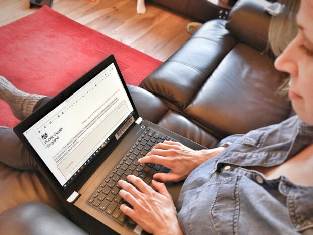 A woman fills in the survey on her laptop.