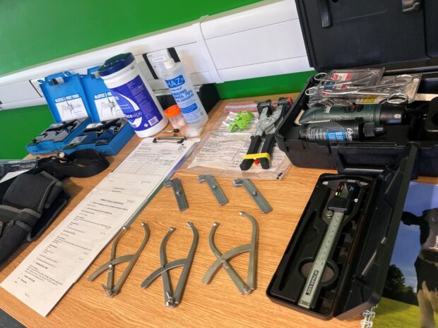 Range of callipers and other instruments in boxes laid out on a table.
