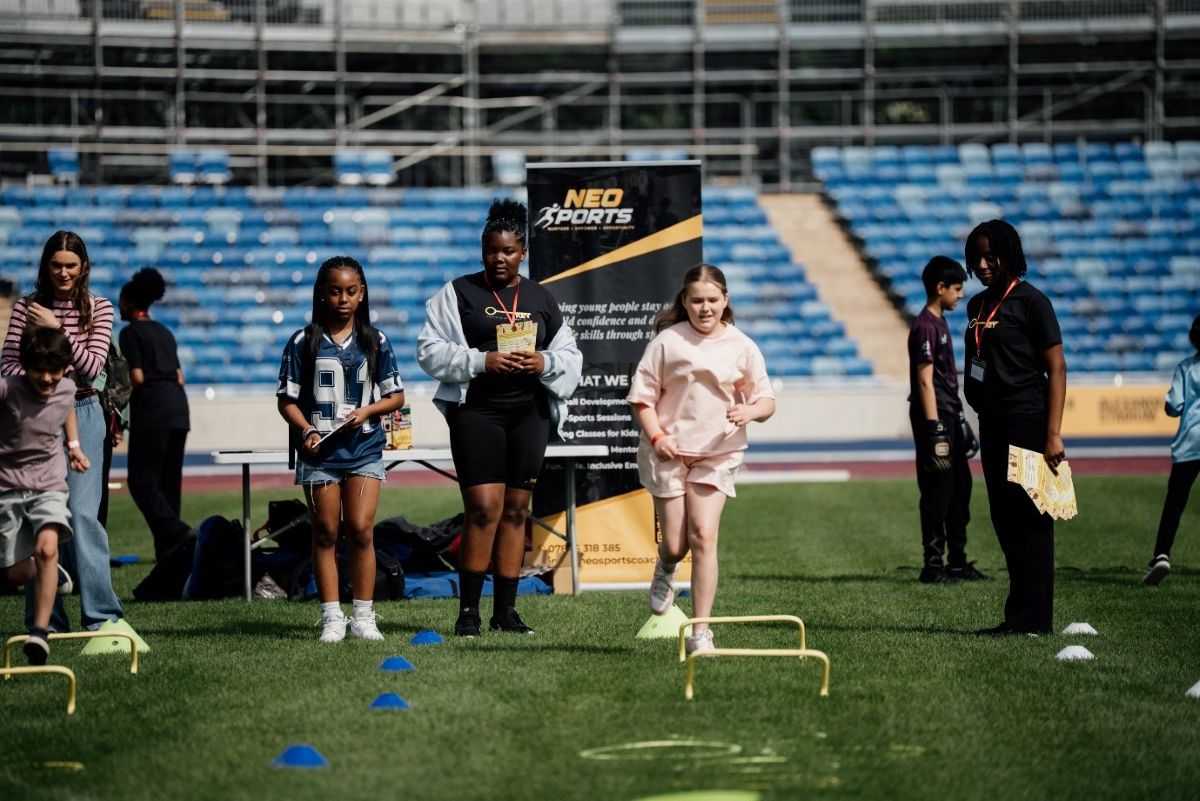 A group of children running during an inclusive festival for sport.