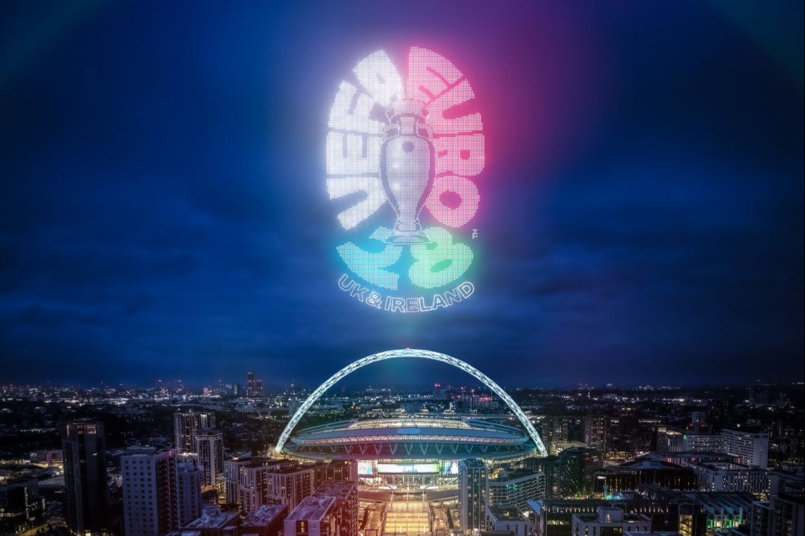 Wembley Stadium lit up at night with UEFA EURO 2028 logo above.