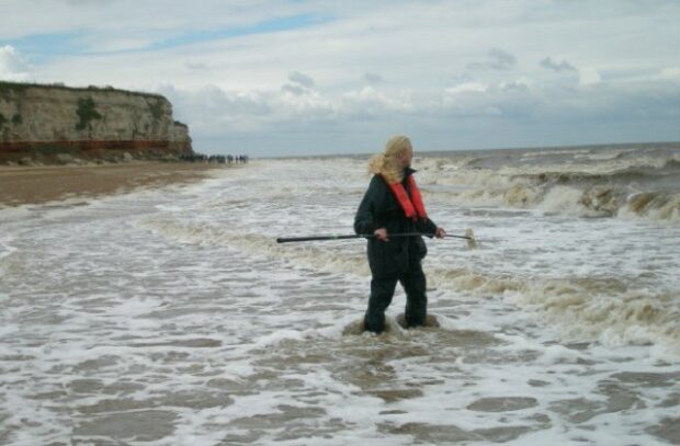 A person standing knee deep in the sea looking out into the ocean