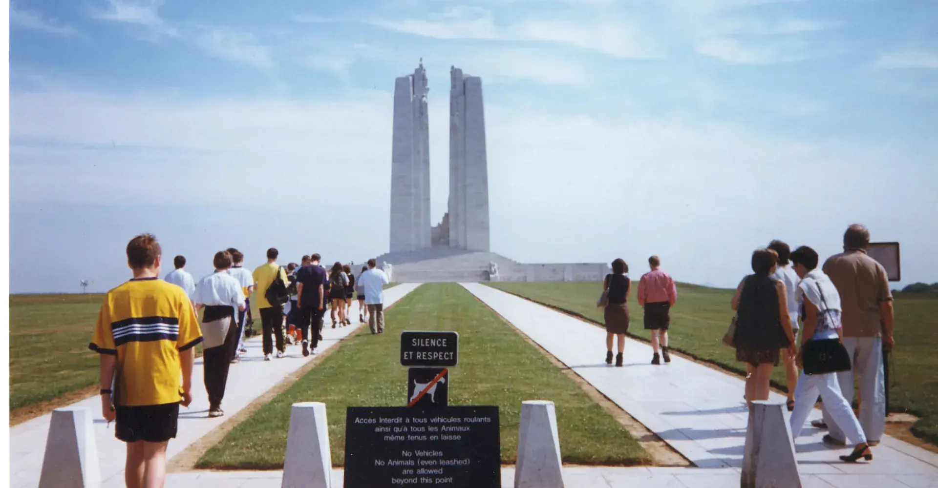 A group of young people walking towards a war memorial