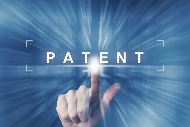 A finger pointing to the word patent
