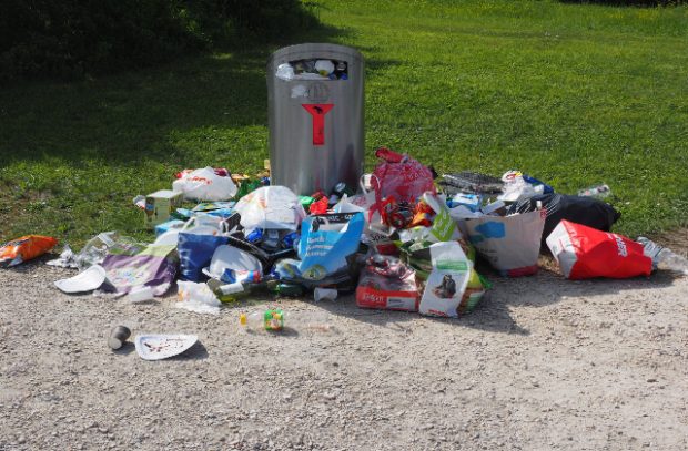 Litter strewn around an overflowing bin.
