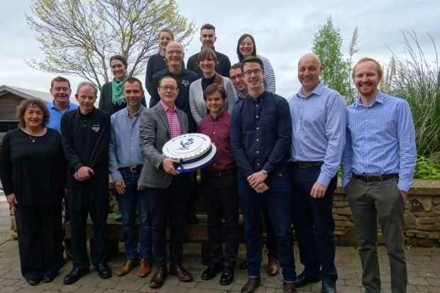 Bettys & Taylors team hold up a Queens Awards cake.