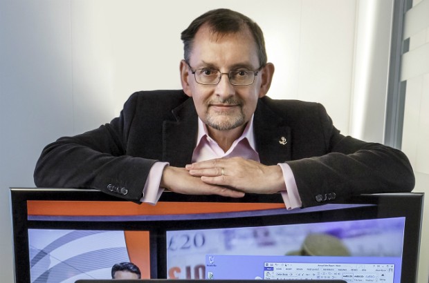 Dr Andy Harter leaning on a computer monitor.