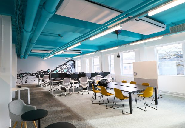 Classroom with exposed pipes and ventilation.