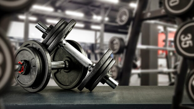 Metal dumbbells and blurred gym interior.