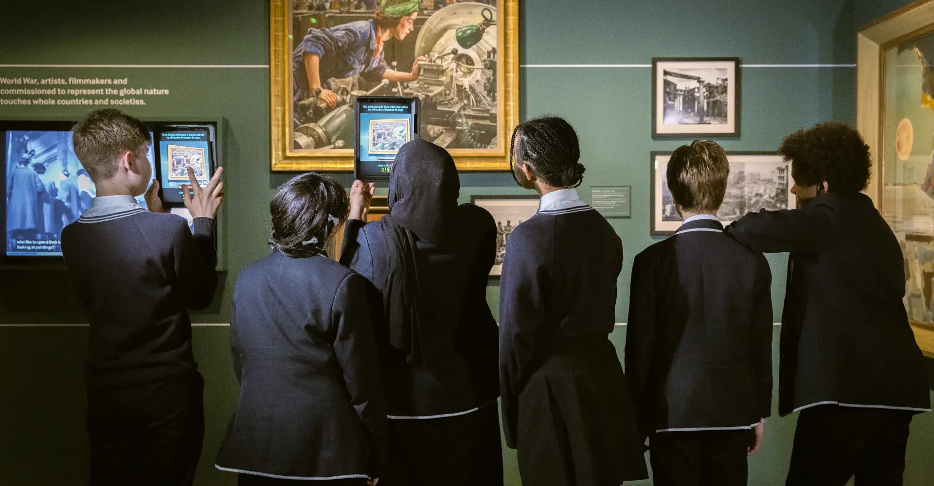 A group of students on-gallery interacting with the artworks. 