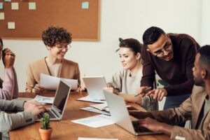 Image of multi ethnic colleagues around a desk, depicting diversity and inclusion