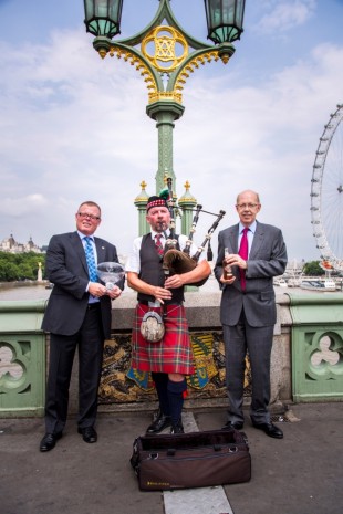 Tony Hunt and Peter Mielzynski from The Innis & Gunn Brewing on Westminster Bridge with a bagpiper