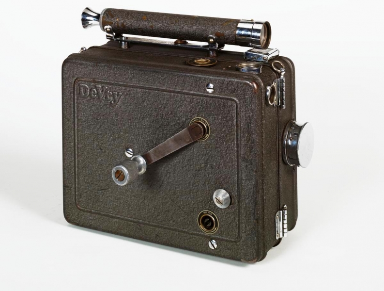 The De Vry Standard was a rugged, all-metal newsreel-type cine camera, using 33mm 100ft film spools.Using a spring motor, it was nicknamed "The Lunch Box" because of its rectangular shape. The De Vry was the camera most widely used by members of the British Army Film and Photographic Unit during the Second World War.