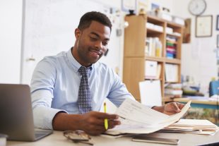 African American male teacher working at his desk