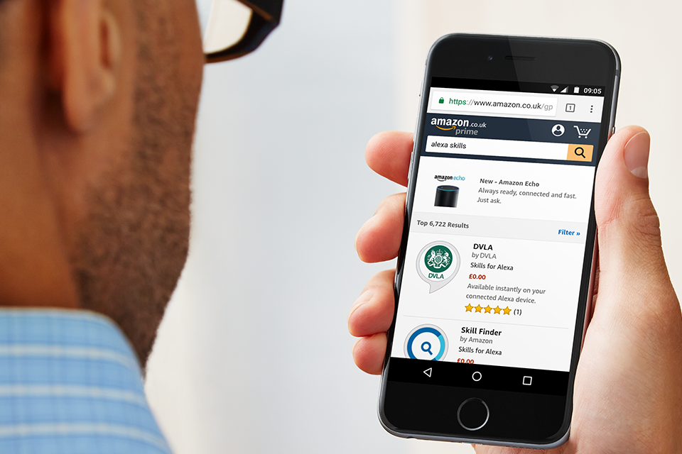 Man holding mobile phone showing Alexa app within Amazon store