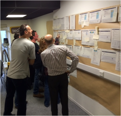 DVLA staff looking at paper copies of each service placed on a wall