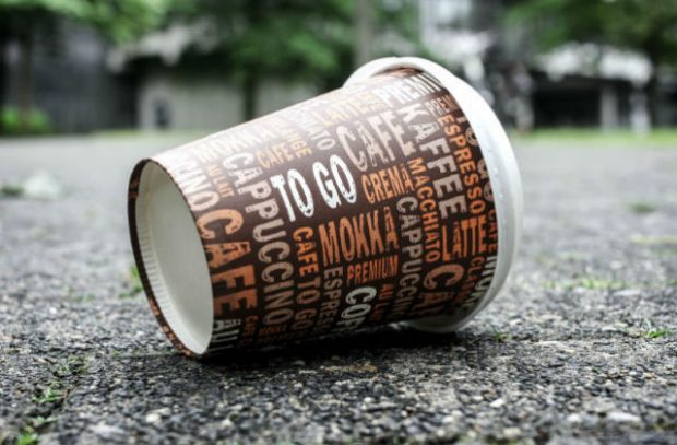 A disposable coffee cup on the ground.