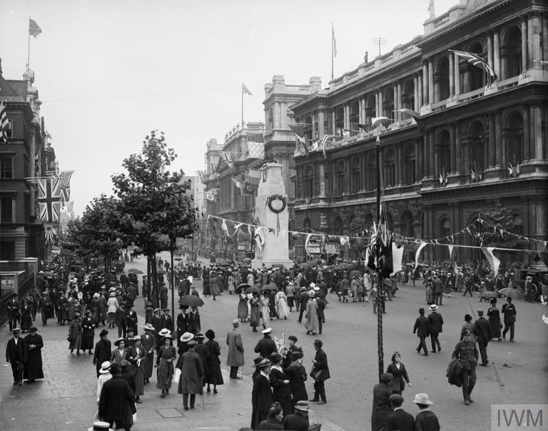 People gathering around the Cenotaph (A big large sculture) They are lulling around it and seeing what is happening.