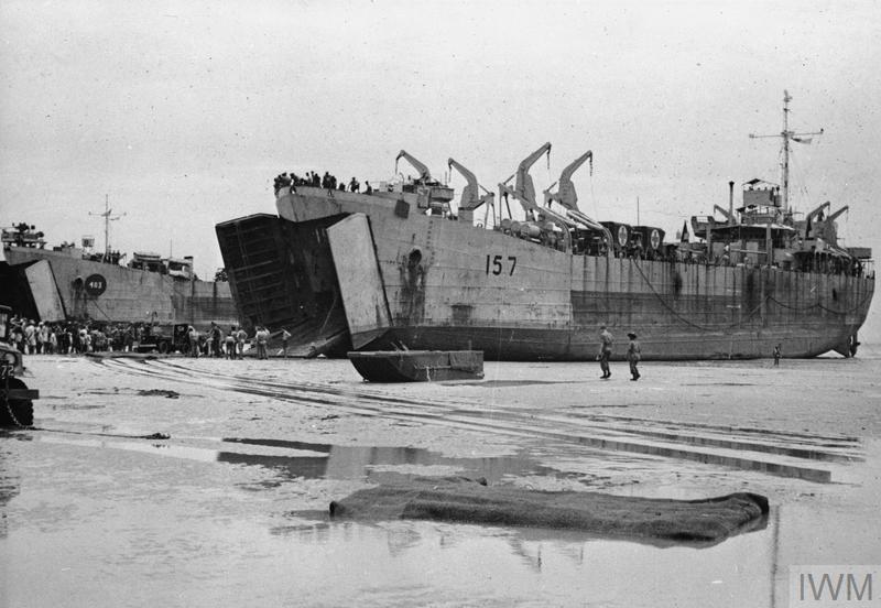 A beached warship, surrounding by soldiers and other debris