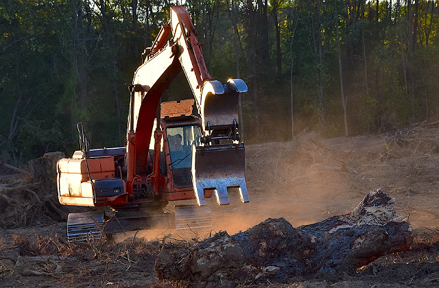 An image of a bulldozer in the process of removing soil from the ground.