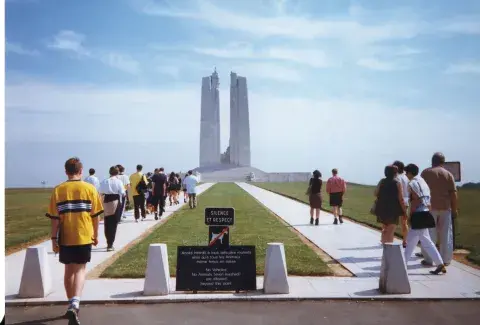 A group of young people walking towards a war memorial