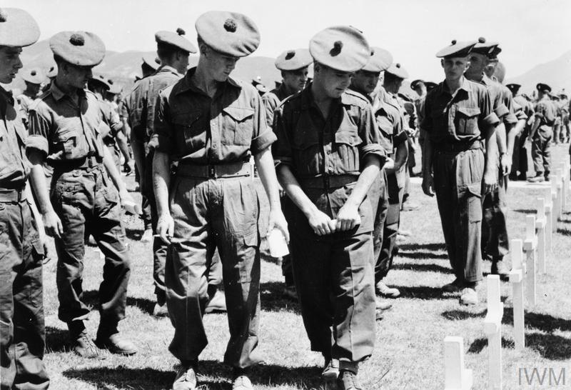 Two soldiers from the King's Own Scottish Borderers, pass British crosses in the UN Cemetery in Pusan, where a memorial service was held for fallen comrades.