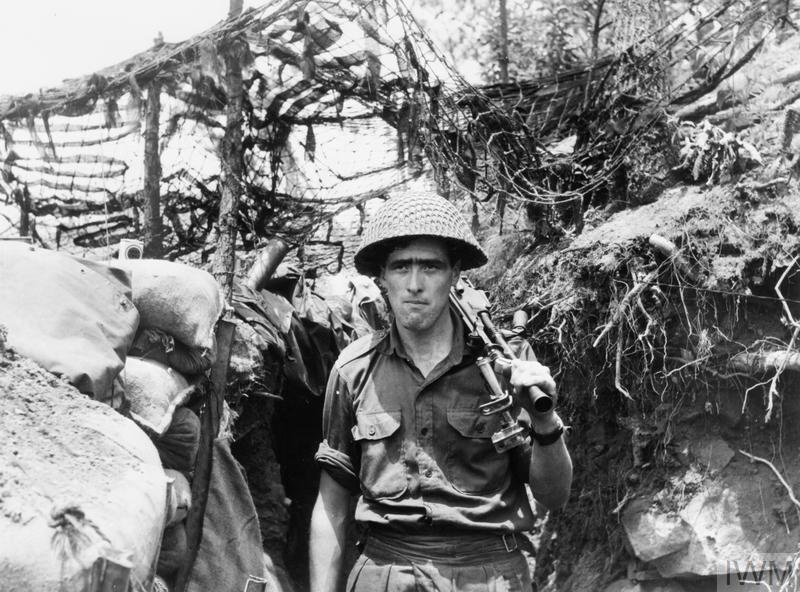 Walking along a typical hillside trench is Private Jack Crawford of Company A, 3rd Battalion, Royal Australian Regiment.