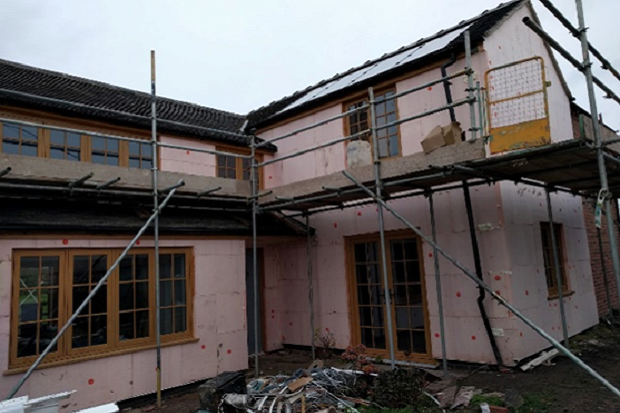 HOUSE UNDER RENOVATION, WITH SCAFFOLDING SURROUNDING IT.