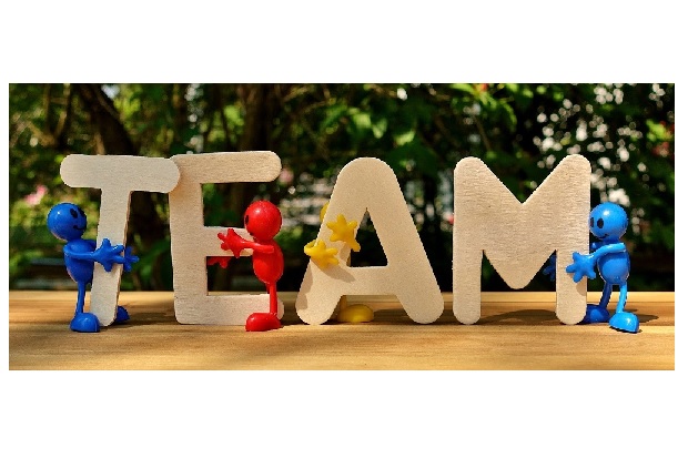 Plastic human figures holding up a sign saying the word TEAM