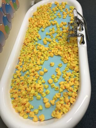 Photo of a release the Pressure exhibit, consisting of a bath full of yellow rubber ducks