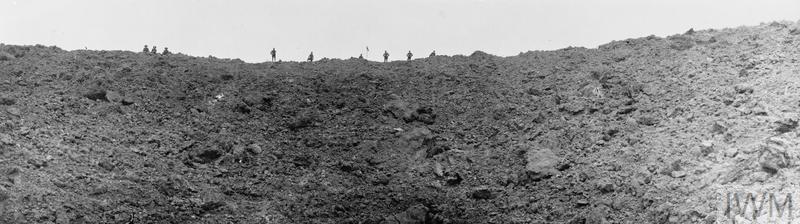 British soldiers stand looking into the huge mine crater at Messines Ridge, blown up on the morning of the battle. Photographed on 11 June 1917