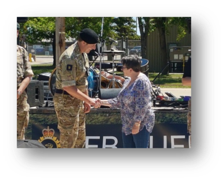 Josephine Deneve receiving her Commander's Coin from BATUS Commander Col. Marcus Evans. [Crown Copyright/MOD]