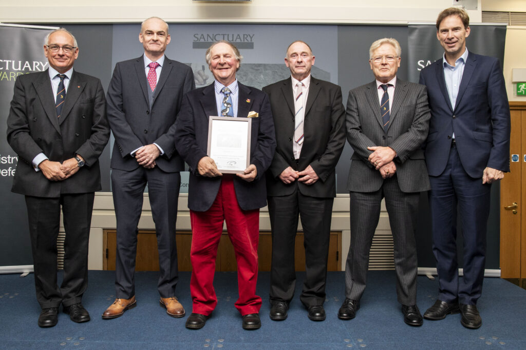 Members of the Army Ornithological Society who worked on the Ascension Seabird Conservation Project pose with their runners up award and Minister of Defence Personnel and Veterans, Tobias Ellwood MP.