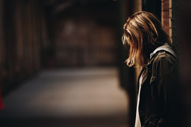 Teenage girl leaning against a wall