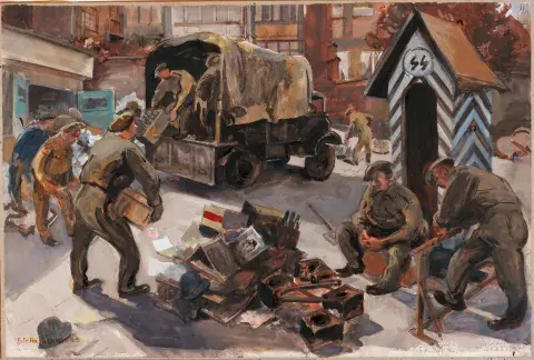British soldiers unload boxes from the back on an army truck in a courtyard and empty them into a pile on the floor. Two soldiers watch from the sentry box.
