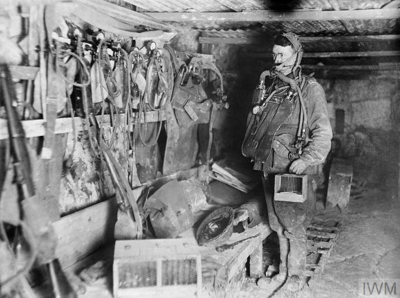 The interior of 3rd Australian Tunnelling Company's Mine Rescue Station at Hulluch, near Loos, France, 31 January 1918. The sapper wears the 'Proto' breathing apparatus and carries a small cage containing a white mouse or canary for testing the air conditions underground.