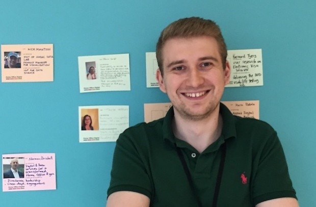 Chris Bayley, Digital, Data and Technology Fast Streamer, standing in front a wall with post-it notes
