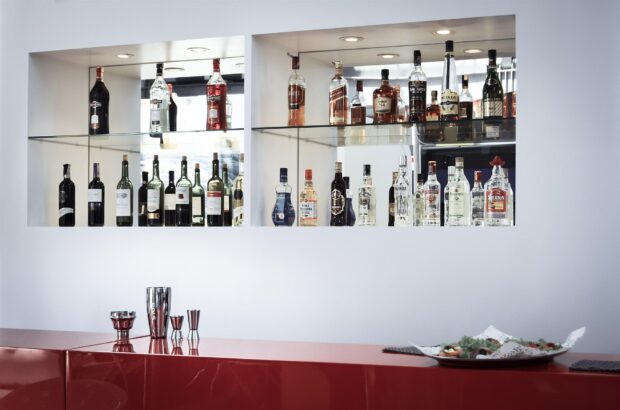 bottles of drinks on shelves behind a bar 