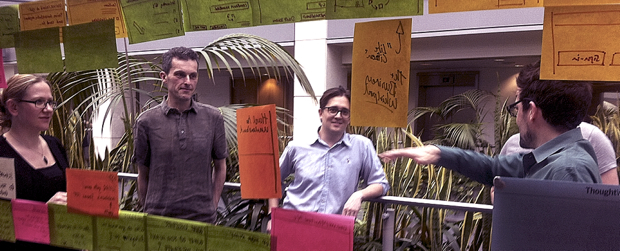 GDS agile project team working together looking at post its on a glass wall
